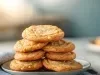 Em cima de uma mesa, prato branco com biscoitos redondos crocantes enfileirado em cima do outro.
