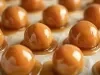 Em cima de uma mesa, balas com caramelo crocantes.