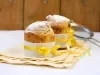 Fotografia mostra um mini panetone em forminha branca, com um laço amarelo em volta.