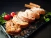 Em cima de uma mesa, prato com cinco rabanadas, polvilhadas com açúcar de confeiteiro.