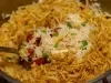Espátula  cheia arroz com ervilha, pedaços de bacon e batata palha.