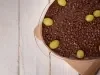 Imagem de travessa de vidro com ganache de chocolate, 
decorada com uvas inteiras e chocolate granulado