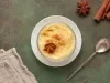 Fotografia mostra tigela branca com mingau de fubá cremoso, polvilhado com canela.