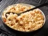 Em cima de uma mesa, tigela redonda com arroz soltinho com uvas-passas brancas.
