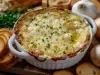 Recipiente de porcelana branca com queijo gratinado e pedaços de cebolinha picada.