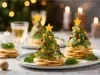 Em cima de uma mesa, prato redondo com bolachas. Em cima das bolachas creme em formato de árvore de natal, decorado com pedaços de cheiro verde e um pedaço de queijo em formado de estrela.
