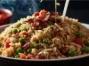 Em cima de uma mesa, tigela com arroz soltinho, bacon picado em pedaços, ervilhas, cenoura picadas, decorado com salsinha picada.