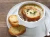 Sopa de cebola gratinada com pão crocante e queijo derretido em cumbuca branca