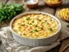 Em cima de uma mesa, recipiente de porcelana redondo com queijo gratinado, decorado com salsinha picada.