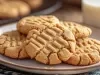 Em cima de uma mesa, biscoitos redondos crocantes com listas feitas com um garfo.