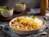 Imagem de um prato redondo com arroz, batata palha e strogonoff de frango cremoso. Compondo a imagem temos um saleiro, um potinho de salsinha e um potinho de batata palha.