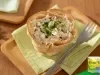 Torta de frango com recheio cremoso servida em massa dourada, finalizada com ervas verdes.