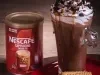 Foto da receita de cappuccino crocante servida em uma caneca alta de vidro sobre uma mesa de madeira
