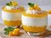 Fotografia em tons claros de dois recipientes de vidro pequenos com a sobremesa, o creme e o abacaxi bem caramelizado.