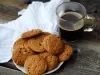 Em cima de uma mesa, prato com biscoitos em redondos crocantes e dourados.