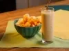 imagem mostra um copo de refresco amarelo cremoso preparado com manga, maracujá e abacaxi