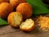 Receita de Bolinho de Piracuí Paraense, visto bem próximo com um bolinho aberto na metade e mostrando o recheio