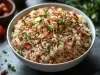 Em cima de uma mesa, porção de arroz com bacon picado.