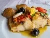 Em cima de uma mesa, prato com porção de bacalhau com azeite e tomate, pimentão, batatas e azeitonas.