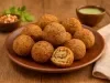 Receita de Bolinho de Piacuí Paraense servido em um prato marrom, em pequenas bolinhas, com um molho ao fundo e uma vinagrete