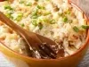 Close de bacalhau com natas gratinado, com pedaços de bacalhau, batata e cebolinha em refratário.