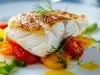 Prato redondo com porção de bacalhau e legumes em rodelas.