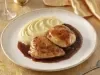 Pedaços de frango dourados servidos com purê cremoso de batata e molho escuro reduzido, apresentados em prato branco elegante
