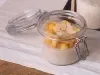 receita de overnight oats proteico servida em um pote hermético sobre uma mesa de madeira com pano branco