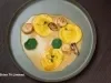 Tortelloni de camarão com molho bisque, vieiras grelhadas e flores de capuchinha em prato sofisticado e cheio de sabor.