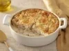 Caçarola cremosa assada com frango e molho branco, gratinada com superfície dourada, servida em refratário branco.