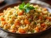 Em cima de uma mesa, tigela com porção de arroz soltinho e cremoso com cenouras picadas em rodelas e decorado com folha de salsa.