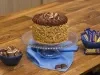 Foto aproximada da receita de Bolo Charge, decorado com amendoins e chocolate, sobre uma bancada de madeira, com alguns bombons Charge ao redor