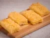 Fatias de bolo de macaxeira com coco ralado servidas em tábua de madeira