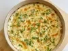 Visto de cima, prato de porcelana bege com queijo gratinado, decorado com cheiro-verde picado.