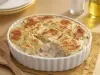 Caçarola cremosa assada com frango e molho branco, gratinada com superfície dourada, servida em refratário branco.