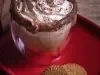 Foto vista de cima da receita de cappuccino avelã servida em um copo de vidro sobre uma louça vermelha