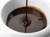 Imagem bem aproximada de um bowl branco com calda de chocolate caindo em fio.