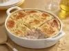 Caçarola assada de atum e salmão em molho cremoso, com superfície dourada gratinada, servida em refratário oval branco.