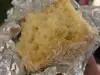 Fatia de bolo gelado de coco envolta em papel-alumínio, mostrando massa clara e textura macia.