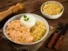 Imagem de um prato com arroz, batata palha e strogonoff de frango. Ao lado, um pote de batata palha e um pimenteiro.