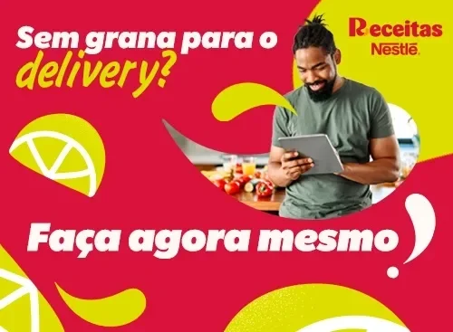 Homem sorridente segurando tablet em cozinha, com texto ‘Sem grana para o delivery? Faça agora mesmo!’.