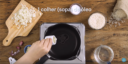 Pessoa derrama óleo de uma xícara na panela